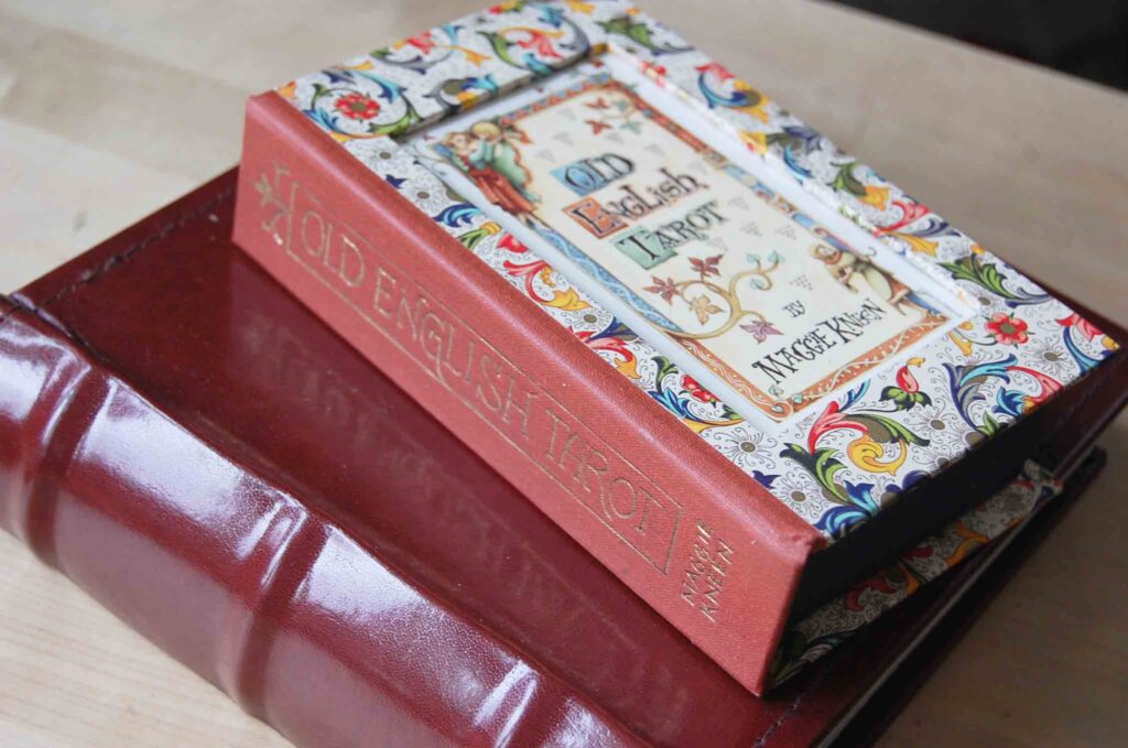 Photograph of a homemade box for a tarot deck with the title card inset on the lid and title - 'Old English Tarot, Maggie Kneen', in gold on the side.